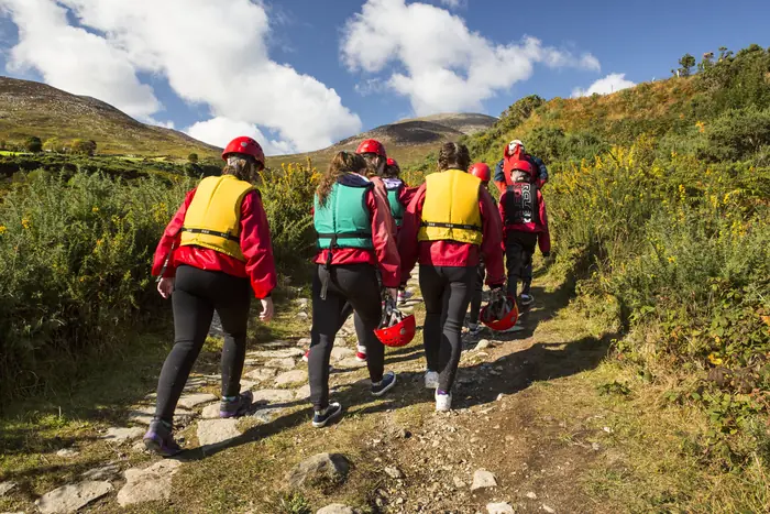 A group in outdoor kit on the coastal path at Bloody Bridge, near Newcastle